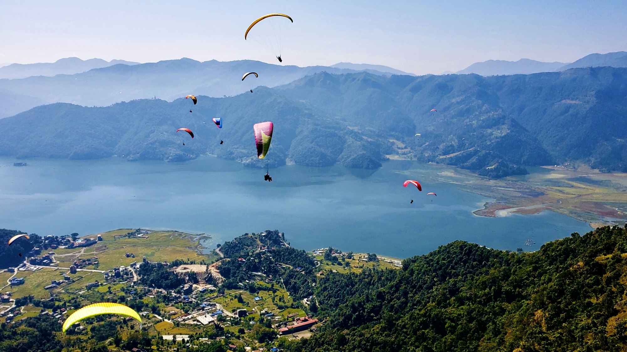 Paragliders over green hills near Pokhara
