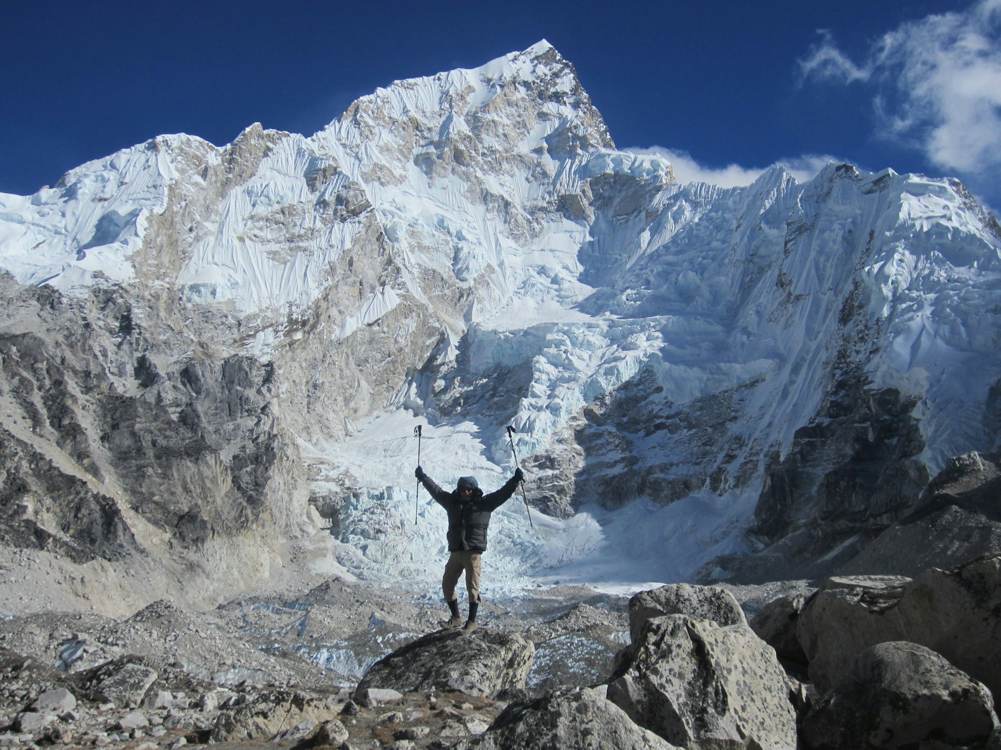 Trekker with arms raised on a Himalayan viewpoint